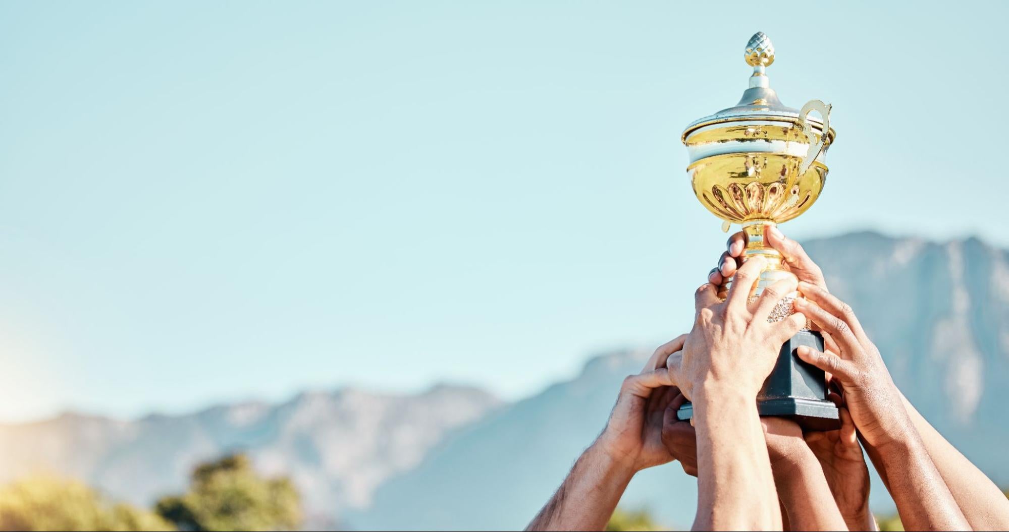 Hands of a sports team with a trophy for an achievement, goal and success together